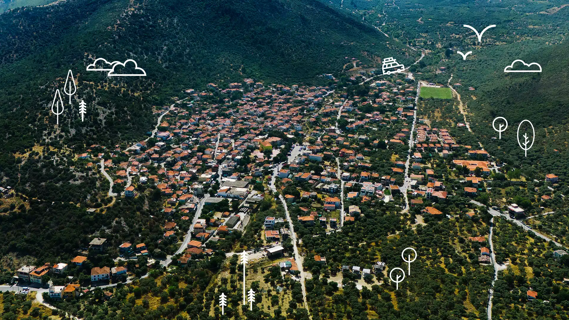 Aerial view of Prinos, a mountain village in Thassos with orange-roofed houses surrounded by tall green mountains Discover Thassos